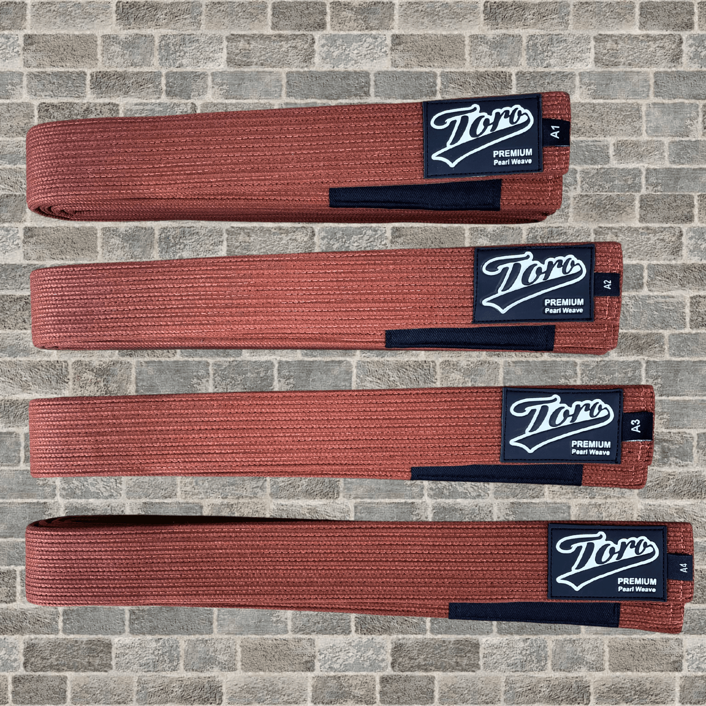 Premium brown BJJ belt with Toro logo patch and black rank bar, displayed on a stone wall background