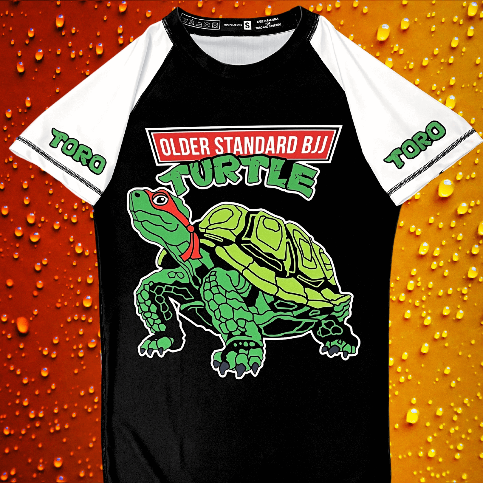 Front view of Toro BJJ rash guard featuring a green cartoon turtle with "Older Standard BJJ Turtle" text, white sleeves with green TORO logos, and a black torso.