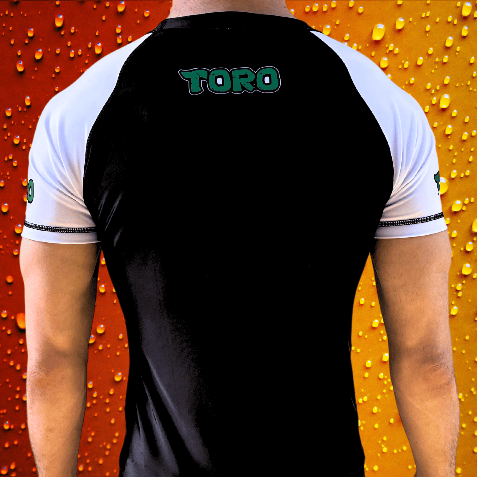 Back view of a person wearing the Toro BJJ Older Standard Turtle rash guard with "TORO" printed across the upper back and white sleeves.