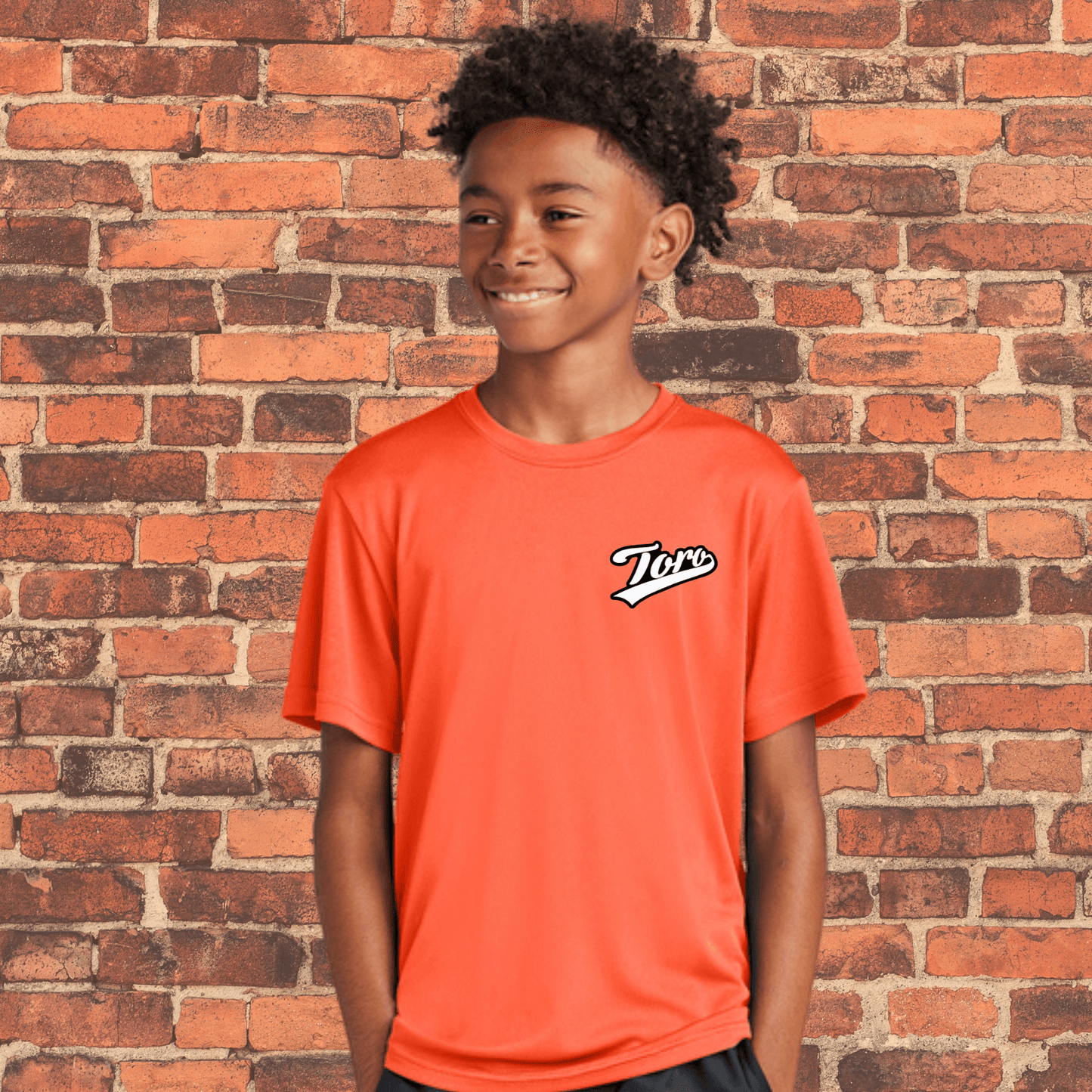 Youth athlete wearing orange ranked BJJ rash guard by Toro, loose fit design ideal for NoGi training or layering under gi