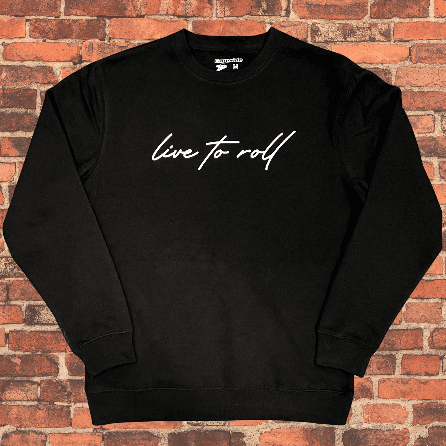Toro “Live To Roll” Crew Neck Sweatshirt flat lay on brick background