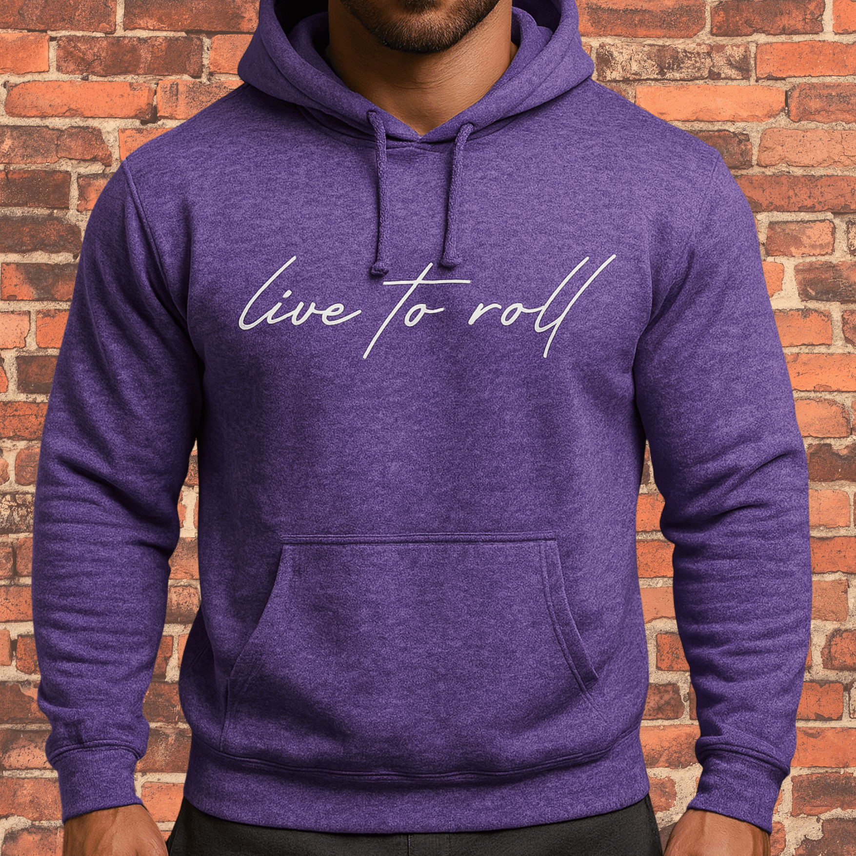 Toro “Live To Roll” Hoodie Heather Purple with white script logo on brick wall background.