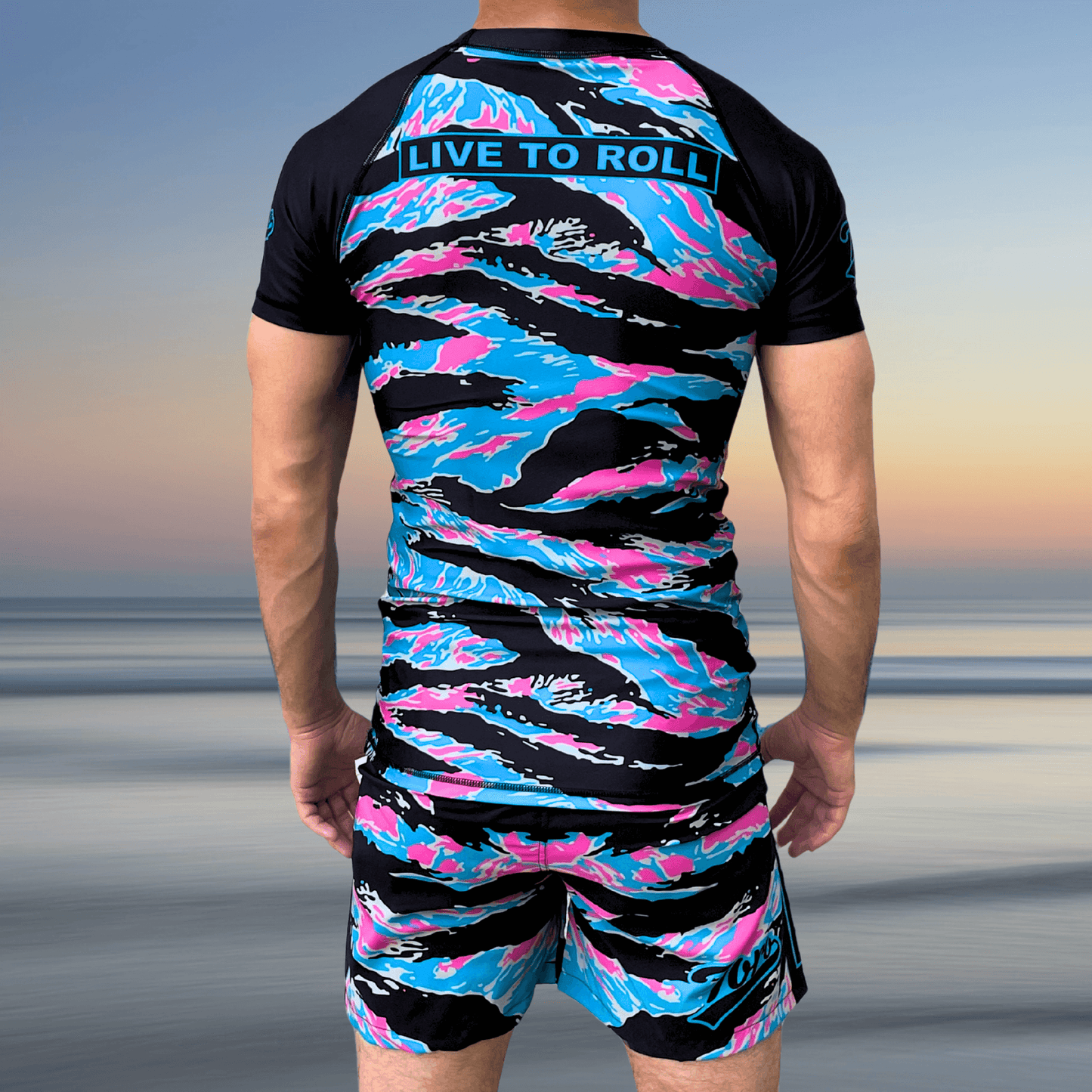 Back view of athlete wearing Toro BJJ Miami Camo rash guard and shorts with "Live to Roll" on the upper back