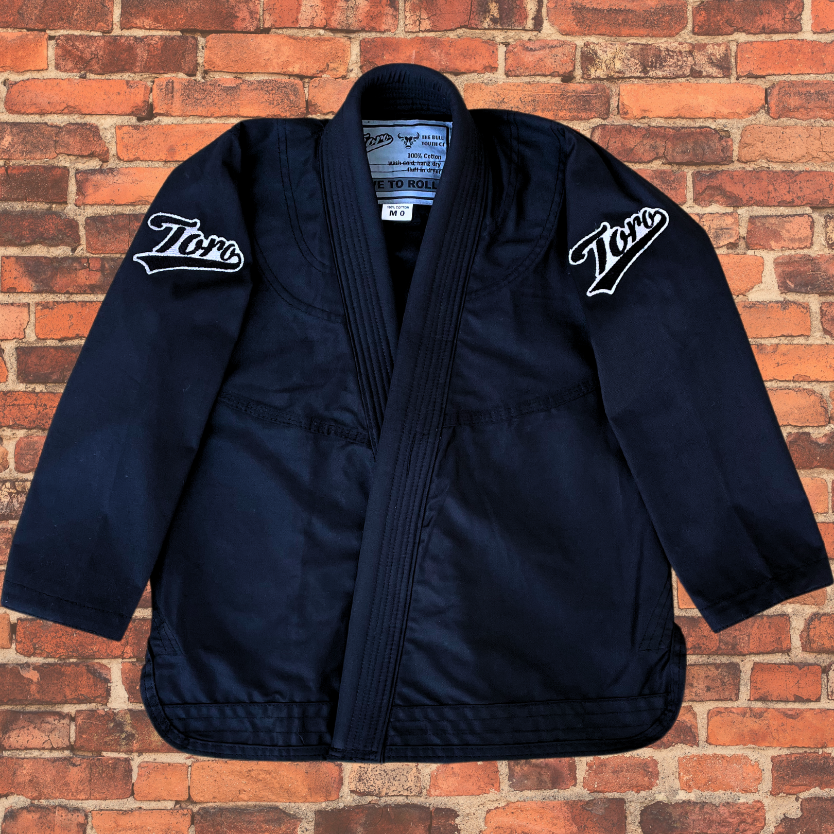 Kids' black BJJ gi top made from durable fabric, designed for comfort and performance, ideal for young martial artists.