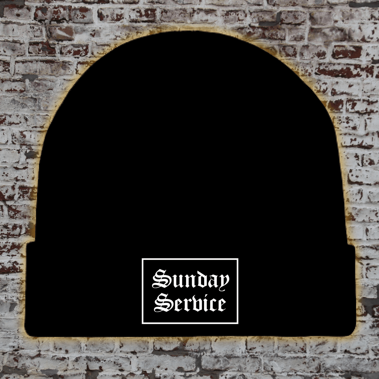 Black knit winter beanie with a white "Sunday Service" logo in a gothic font, displayed on a white brick background with a gold glow around the edges.