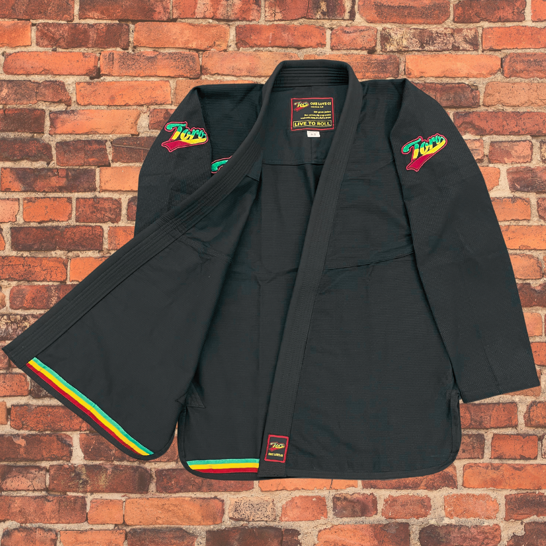 Toro's black BJJ Gi with Rasta trim, Toro logos, 'One Love Gi' patch & 'Live to Roll' tag. Perfect for stylish BJJ athletes.