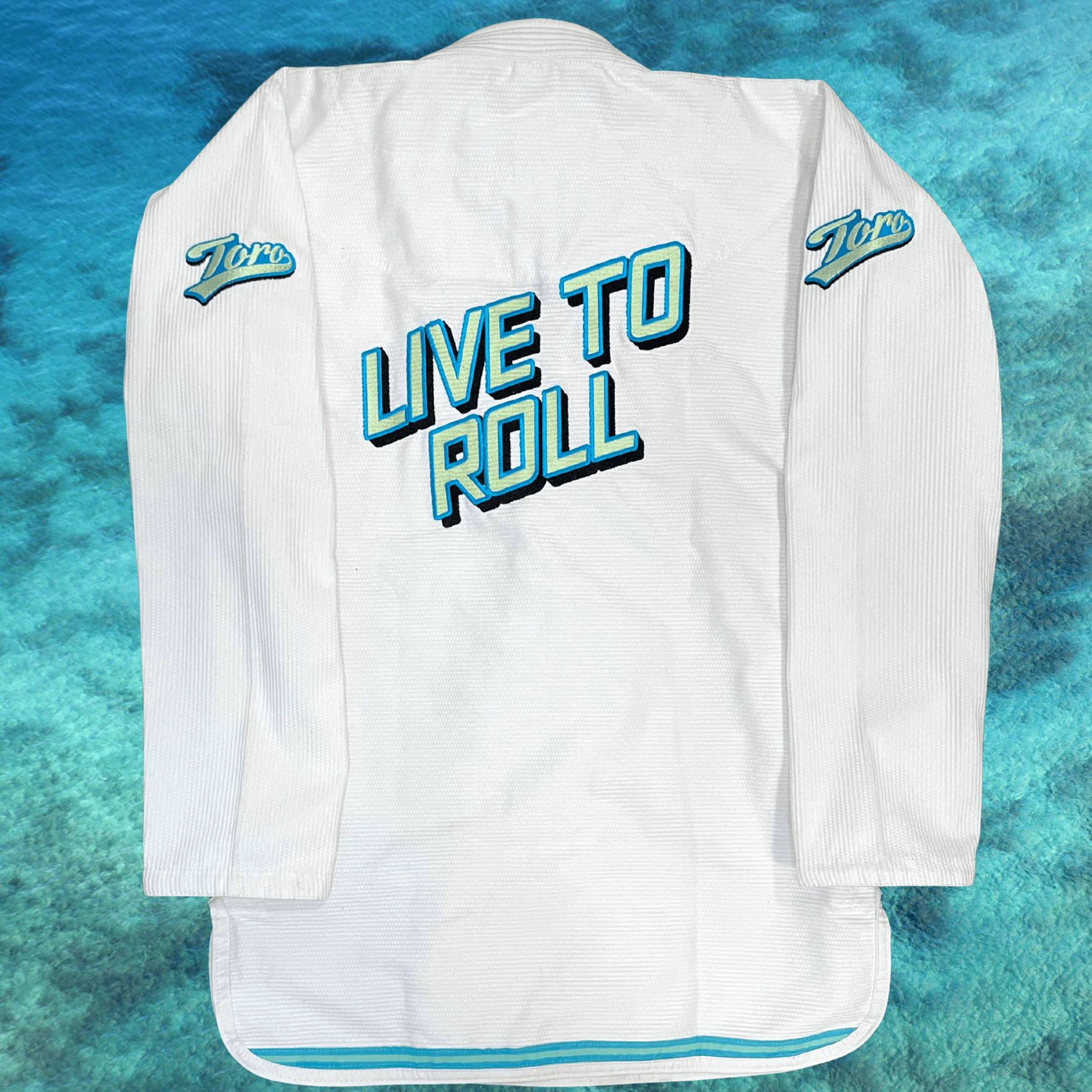 Full back view of white Good Vibes BJJ Gi with large Live to Roll embroidery and Toro shoulder logos