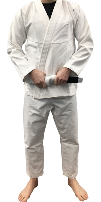 Full-body view of a person wearing the Toro No Logo BJJ Gi, a minimalist white Brazilian Jiu-Jitsu uniform that includes a jacket, pants, and a white belt, perfect for beginners and advanced practitioners alike