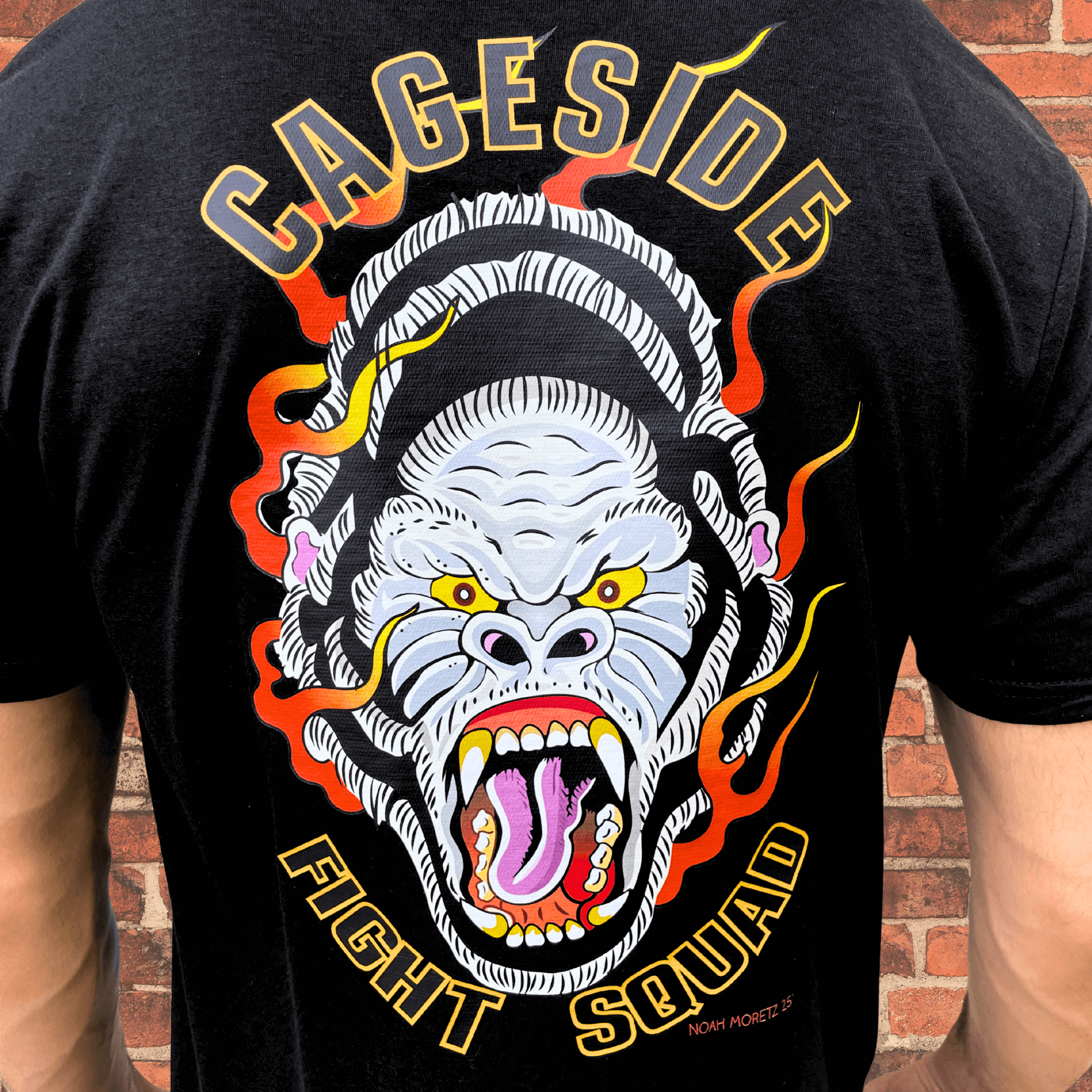 Close-up of back graphic on black Cageside Fight Squad shirt featuring a flaming gorilla illustration with bold text