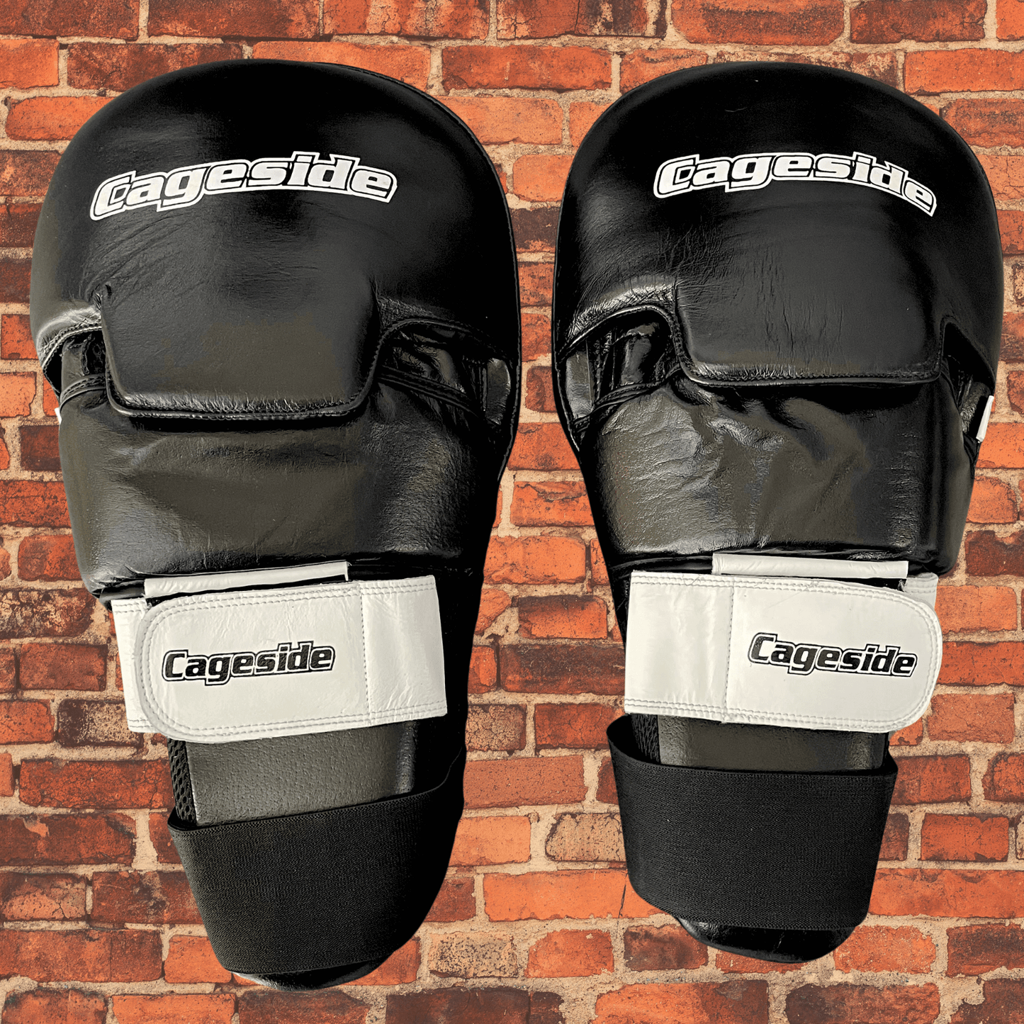 Pair of Cageside Hybrid Mega Mitts black focus mitts with white straps front view