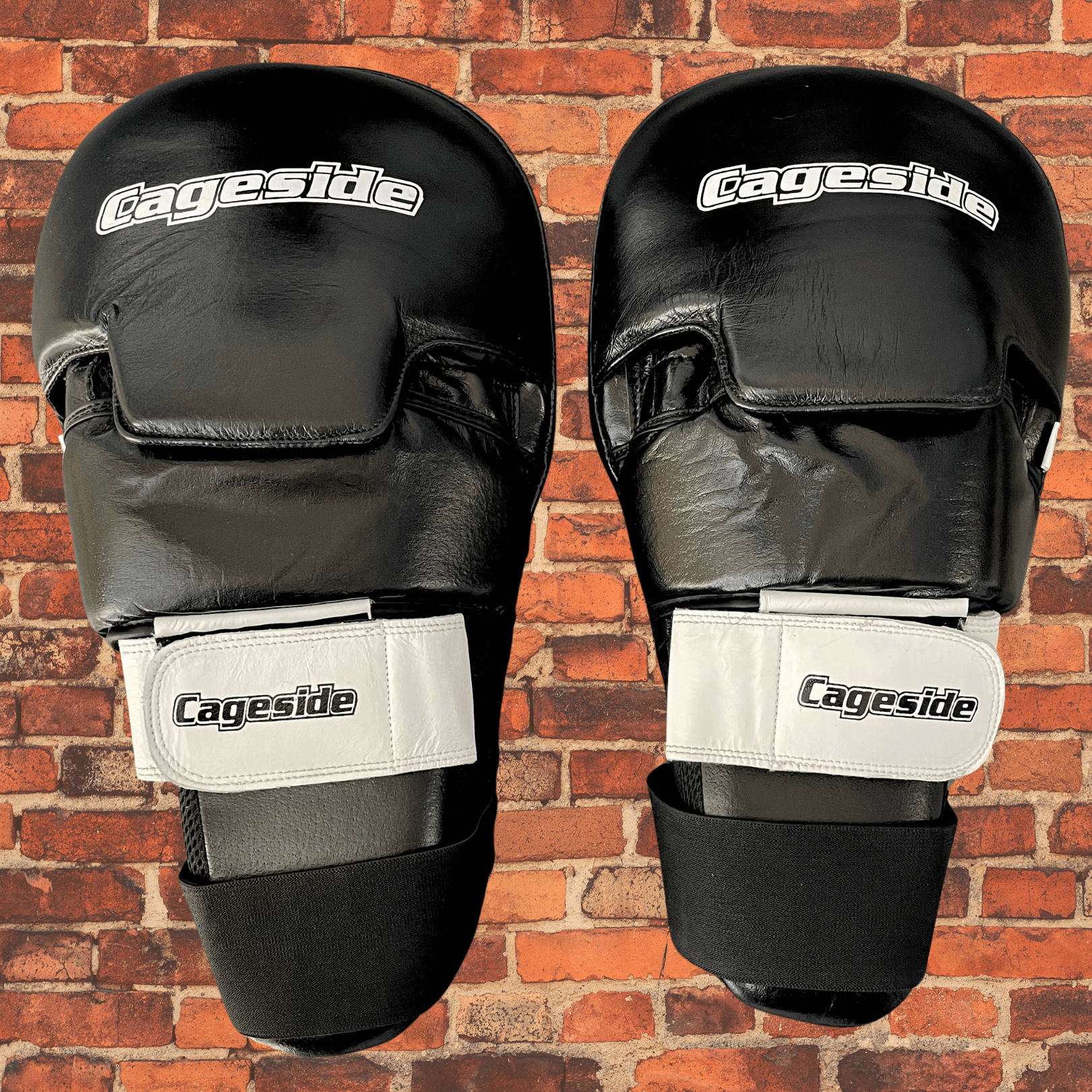 Pair of Cageside Hybrid Mega Mitts black focus mitts with white straps front view