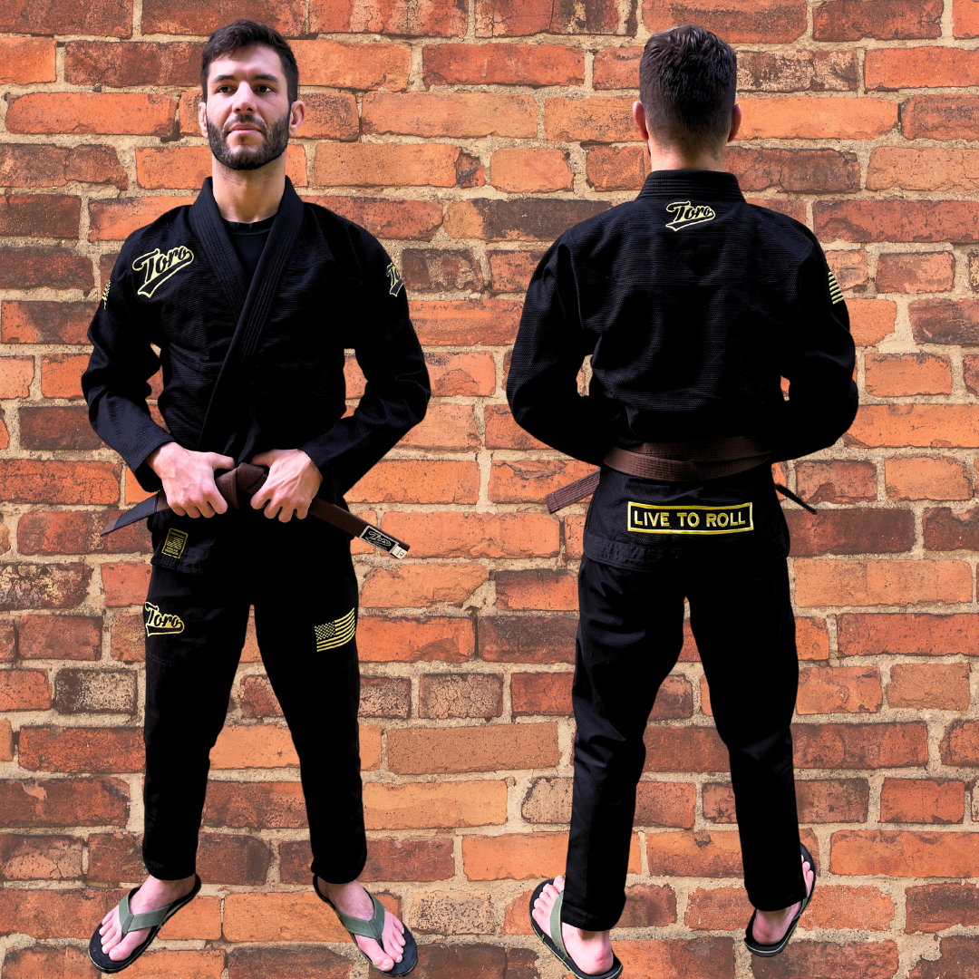 Front and back view of a male BJJ athlete wearing a black Toro Gi with gold accents, standing against a brick wall