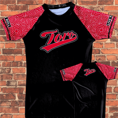 Flat lay of Toro BJJ Black Belt Ranked Rash Guard, black body with red pattern sleeves, Toro logo on chest, Live to Roll patch on sleeve.