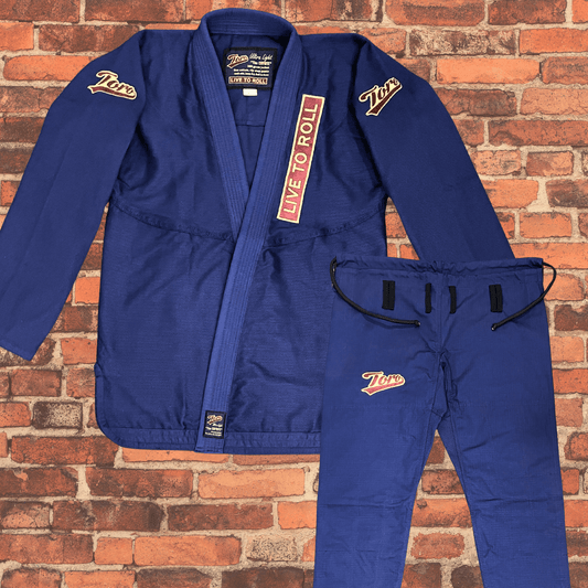 Navy Blue BJJ Gi with jacket and pants laid flat, Toro BJJ Coyote Gi with brown stitching and Live to Roll patch