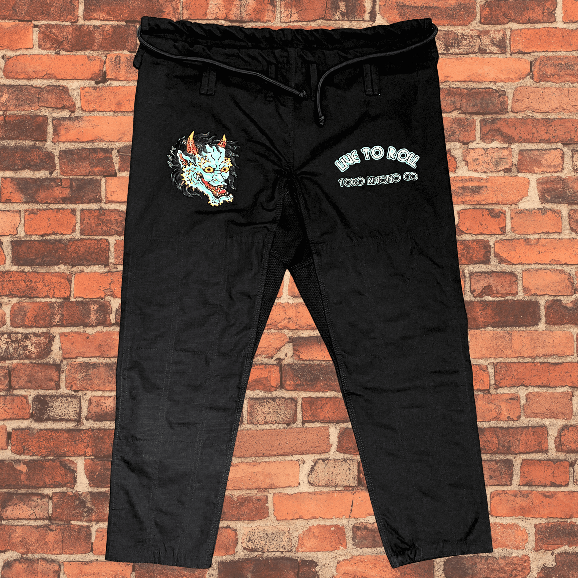 Green Oni BJJ Gi pants full view with Oni embroidery and Live to Roll text