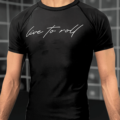 Black short sleeve rash guard with “live to roll” text on chest, worn by male model, for NoGi Jiu-Jitsu training.