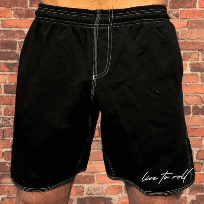 Toro BJJ Live to Roll black shorts with white stitching, ideal for MMA, NoGi Jiu-Jitsu, and casual lounging, worn by male model.