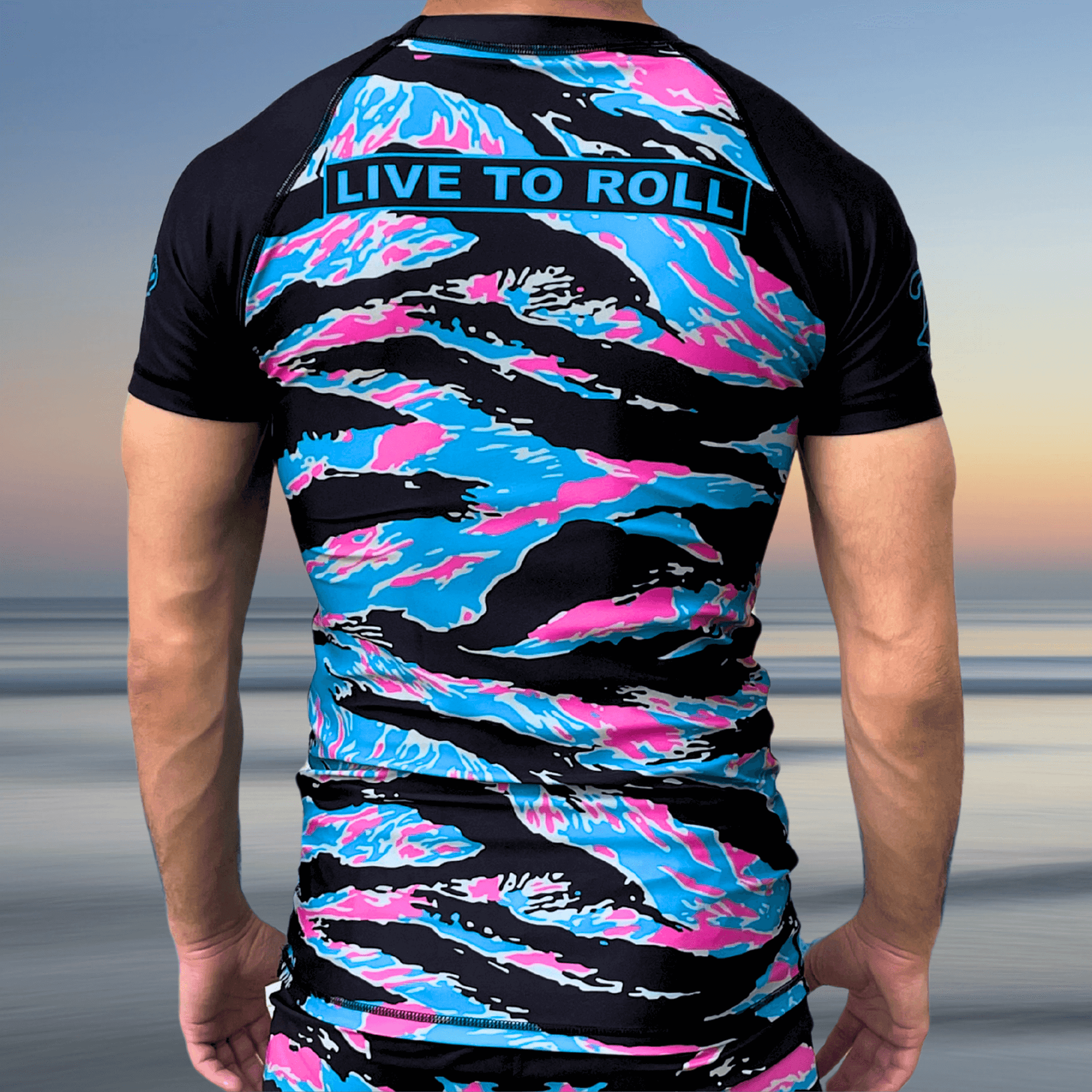 Back view of Miami Camo BJJ rash guard with "Live to Roll" text and pastel camo pattern by Toro BJJ