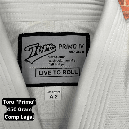 Close-up of the inner label on the Toro Primo White BJJ Gi showing 450 gram weight, 100% cotton material, and “Live to Roll” slogan, with visible A2 size tag and collar stitching detail.