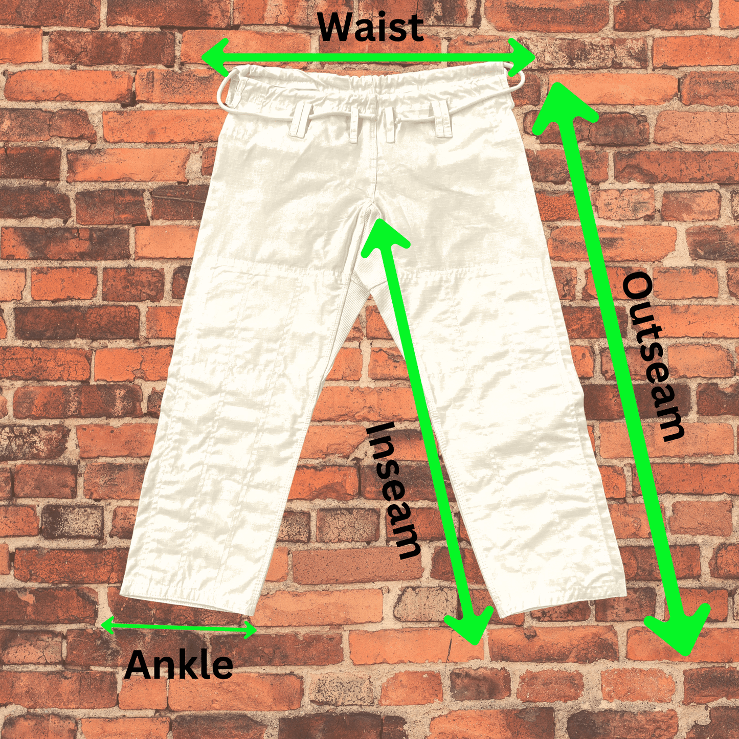 White Toro BJJ gi pants shown with green arrows indicating waist, inseam, outseam, and ankle measurements on a brick wall background.