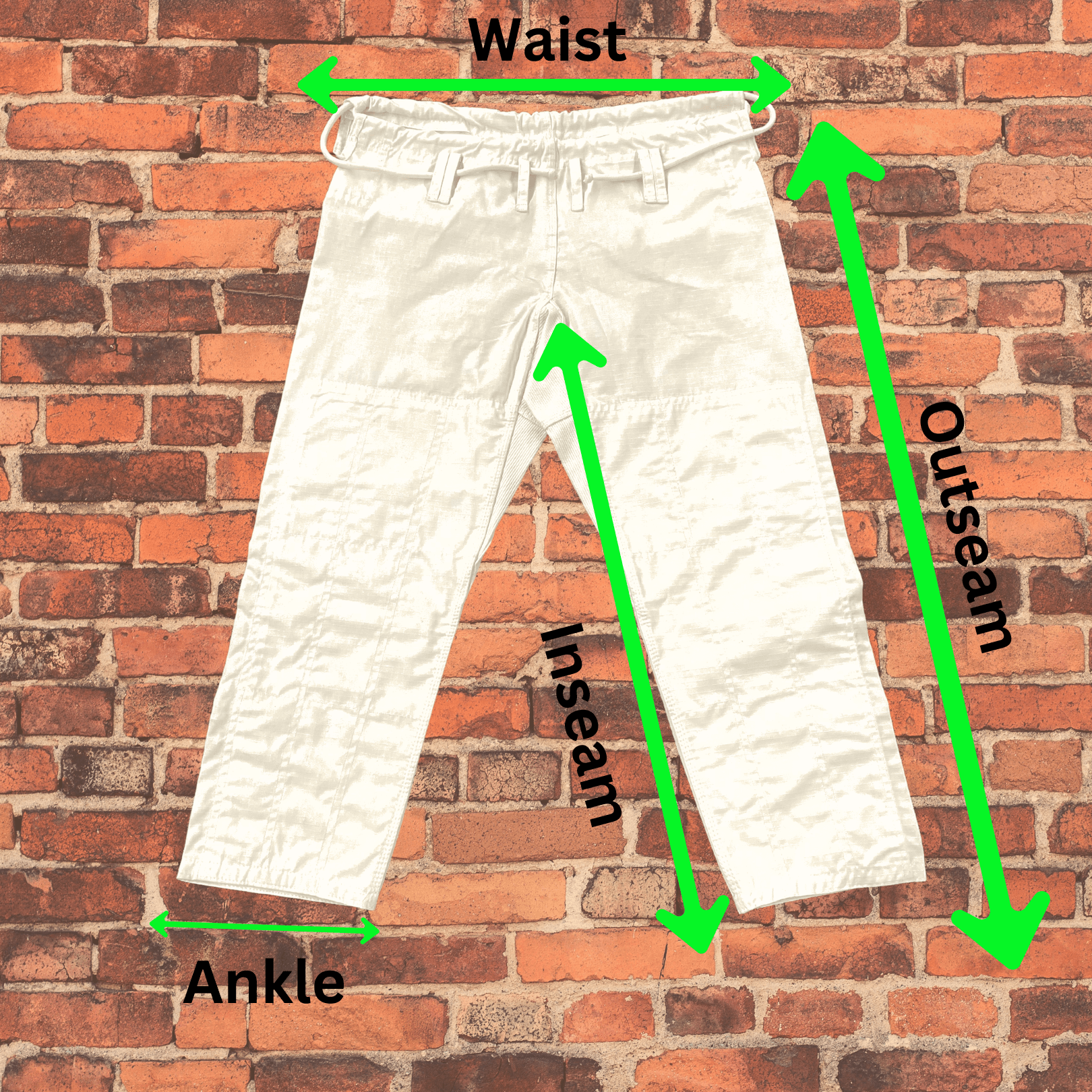 White Toro BJJ gi pants shown with green arrows indicating waist, inseam, outseam, and ankle measurements on a brick wall background.